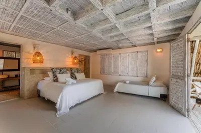 a bedroom with two beds and a wooden ceiling at Isla Matamba in Isla Grande