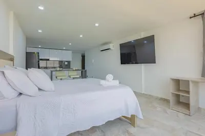 a white bedroom with a large white bed with white pillows at Lujoso apartamento con vista al mar in Cartagena de Indias