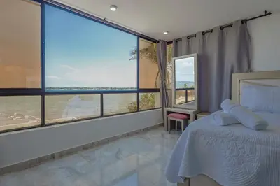 a bedroom with a bed and a large window at Lujoso apartamento con vista al mar in Cartagena de Indias