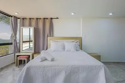 a bedroom with a large white bed with a window at Lujoso apartamento con vista al mar in Cartagena de Indias