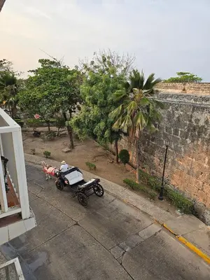 a horse drawn carriage parked next to a brick wall at Apartamento en la ciudad amurallada cerca de todo in Cartagena de Indias