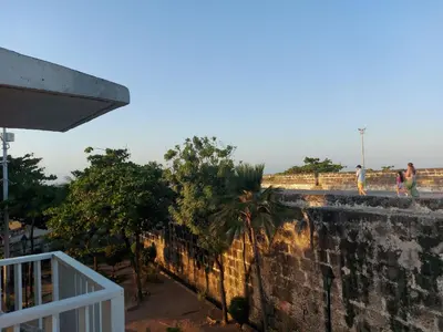 two people walking on top of a brick wall at Apartamento en la ciudad amurallada cerca de todo in Cartagena de Indias