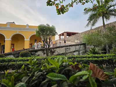 people walking up the stairs of a yellow building at Apartamento en la ciudad amurallada cerca de todo in Cartagena de Indias