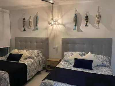 a bedroom with two beds and fish decorations on the wall at Morros 3 con salida al mar y Piscina in Cartagena de Indias