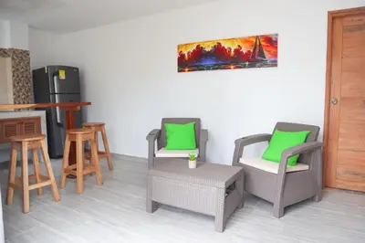 a room with chairs and a table and a refrigerator at Apartamento Villa Carolina 101 in San Antero