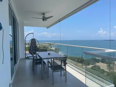 a dining room with a table and chairs on a balcony at Edificio Playa dormida 2 con Piscina y playa in Santa Marta