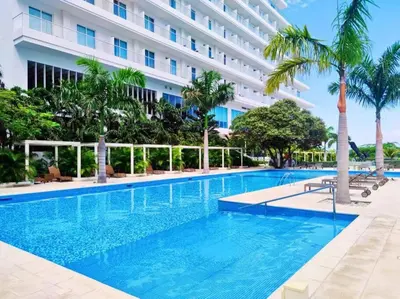 a large swimming pool in front of a building at Edificio Playa dormida 2 con Piscina y playa in Santa Marta