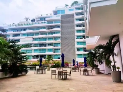 a building with tables and chairs in front of a building at Edificio Playa dormida 2 con Piscina y playa in Santa Marta