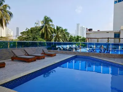 a swimming pool with lounge chairs and a building at Beach retreat in El Laguito in Cartagena de Indias
