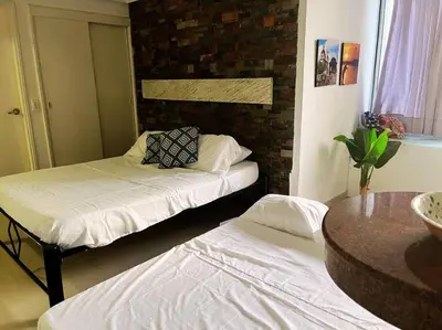 a room with two beds and a table at Beach retreat in El Laguito in Cartagena de Indias