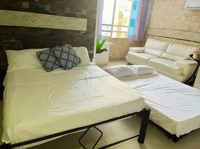 a bedroom with a large bed and a couch at Beach retreat in El Laguito in Cartagena de Indias