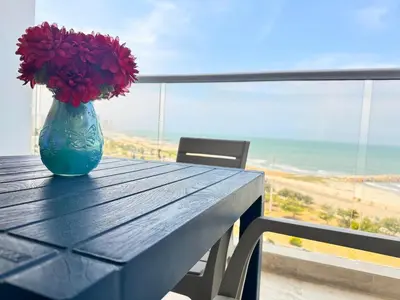 a blue vase with red flowers sitting on a table at Cartagena Suite Lujo Vista Mar 5 min Aeropuerto in Cartagena de Indias