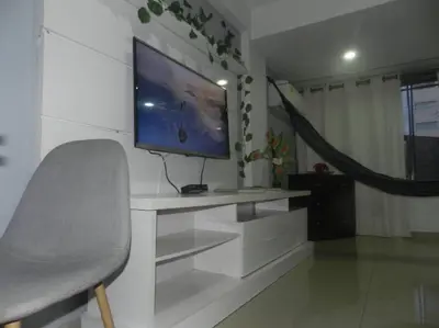 a living room with a tv and a chair at la Ola de la Vida con AA WIFI in Cartagena de Indias