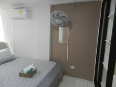 a small room with a bed and a fan at la Ola de la Vida con AA WIFI in Cartagena de Indias