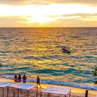 a group of people on a beach with a boat in the water at la Ola de la Vida con AA WIFI in Cartagena de Indias