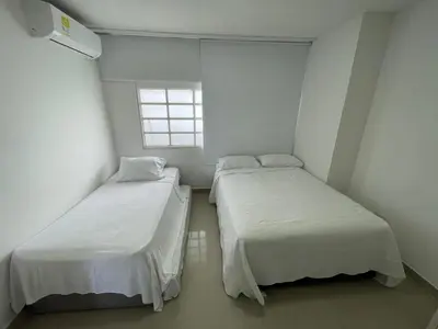 two beds in a small room with a window at Portofino Cartagena Bocagrande 604 ICDI in Cartagena de Indias