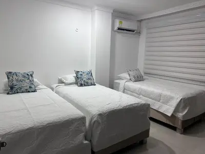 a bedroom with two beds and a window at Antares Apartment in Cartagena de Indias