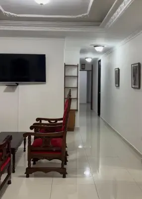 a hallway with a room with a tv and a chair at Antares Apartment in Cartagena de Indias