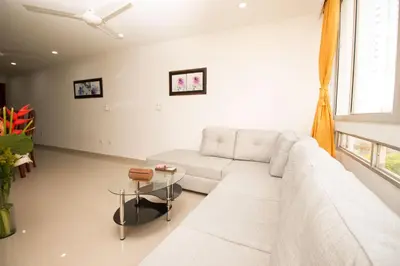 a living room with a white couch and a table at Caribbean Summer - Livin Colombia in Cartagena de Indias