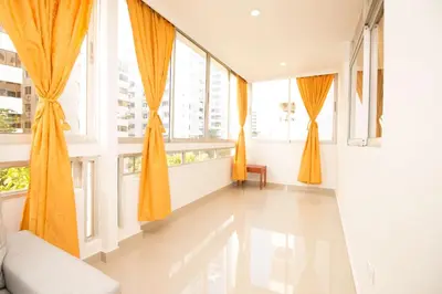 a room with large windows with orange curtains at Caribbean Summer - Livin Colombia in Cartagena de Indias