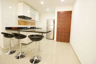 a kitchen with black bar stools and a refrigerator at Caribbean Summer - Livin Colombia in Cartagena de Indias