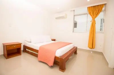a white bedroom with a bed and a window at Caribbean Summer - Livin Colombia in Cartagena de Indias