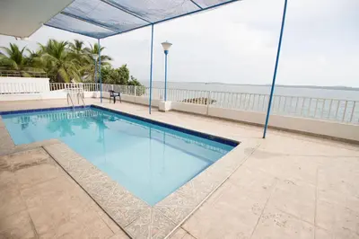 a swimming pool with the ocean in the background at Caribbean Summer - Livin Colombia in Cartagena de Indias