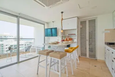 a kitchen with a table and stools in a room at Sensacional! Apartamento Cartagena Morros SeaWay in Cartagena de Indias