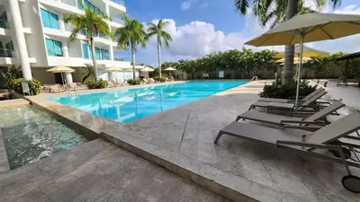a pool at a hotel with chairs and an umbrella at Sensacional! Apartamento Cartagena Morros SeaWay in Cartagena de Indias
