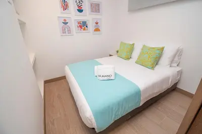 a small bedroom with a bed in a room at U-GO Vistas al Mar desde Murano Centro: Piscina, Jacuzzi y Más in Cartagena de Indias