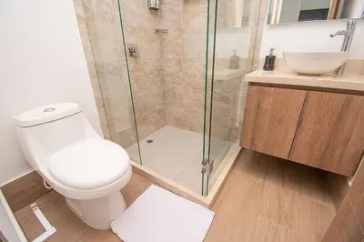 a bathroom with a toilet and a glass shower at U-GO Vistas al Mar desde Murano Centro: Piscina, Jacuzzi y Más in Cartagena de Indias