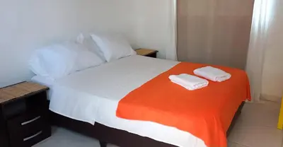 a bedroom with a bed with two towels on it at Hotel Juanmar in Juan de Acosta