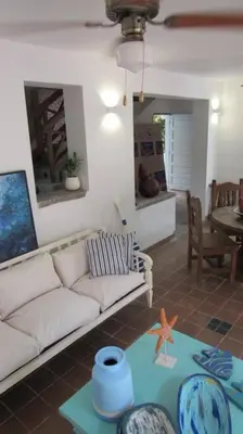 a living room with a white couch and a table at Casa Amin Tolu in San Silvestre
