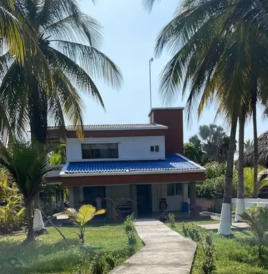 a house with palm trees in front of it at Casa Amin Tolu in San Silvestre