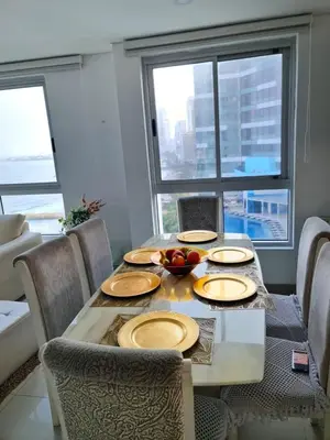 a dining room with a table with plates and fruit on it at Beachfront Luxurious Apartment, Palmetto Beach in Cartagena de Indias
