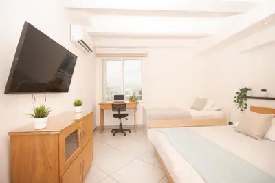 a bedroom with a bed and a television on a wall at Riviera Sunrise Beach - Frente al mar y vista panorámica a toda la ciudad in Cartagena de Indias