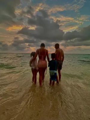 a family walking in the water on the beach at Itaca Eco House in Playa Blanca