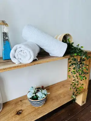 a wooden shelf with towels and a plant on it at Itaca Eco House in Playa Blanca