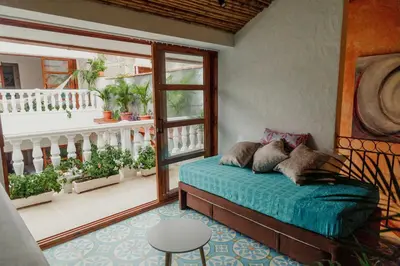 a bedroom with a bed and a balcony with plants at Spiritual Luxury 4BR Pool&Roofterrac Getsemani NEW in Cartagena de Indias