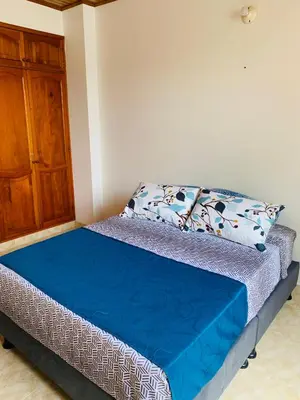 a bed in a room with a pillow and a cabinet at Castillo de la Popa in Cartagena de Indias