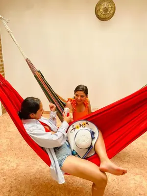 two girls sitting in a hammock with a baby at Castillo de la Popa in Cartagena de Indias