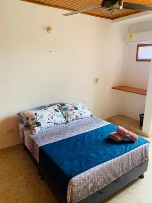 a bedroom with a bed with a blue blanket at Castillo de la Popa in Cartagena de Indias