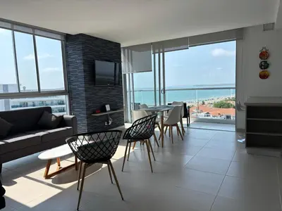 a living room with a couch and a table and chairs at Cartagena SUNNO BEACH in Cartagena de Indias