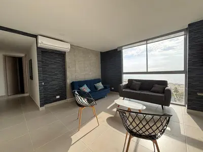 a living room with a couch and a table and chairs at Cartagena SUNNO BEACH in Cartagena de Indias
