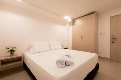 a bedroom with a white bed with towels on it at Casa Mishka Hotel Boutique Habitación #104 Nuevo Cartagena in Cartagena de Indias