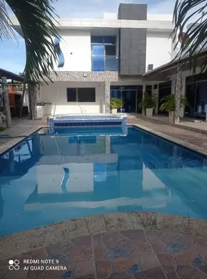 a swimming pool in front of a building at Cabaña campestre Villa Liliana in Juan de Acosta