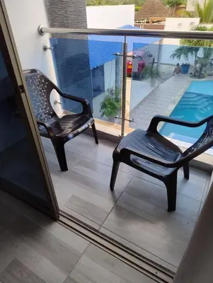 a pair of chairs sitting on a balcony at Cabaña campestre Villa Liliana in Juan de Acosta