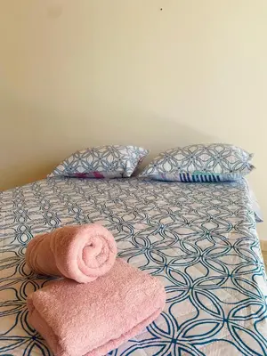 a bed with a pink towel and pillows on it at Hostel Cerca al Centro Histórico in Cartagena de Indias