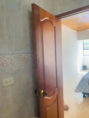 a wooden door in a room with a shower at Hostel Cerca al Centro Histórico in Cartagena de Indias