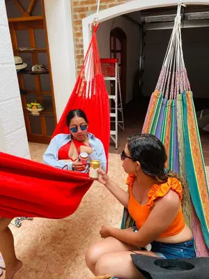 two women sitting in hammocks in a room at Hostel Cerca al Centro Histórico in Cartagena de Indias